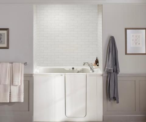 view of walk-in bath with white brick wall surround