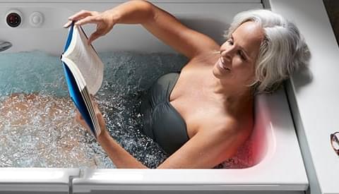 woman relaxing in the bath enjoying a book